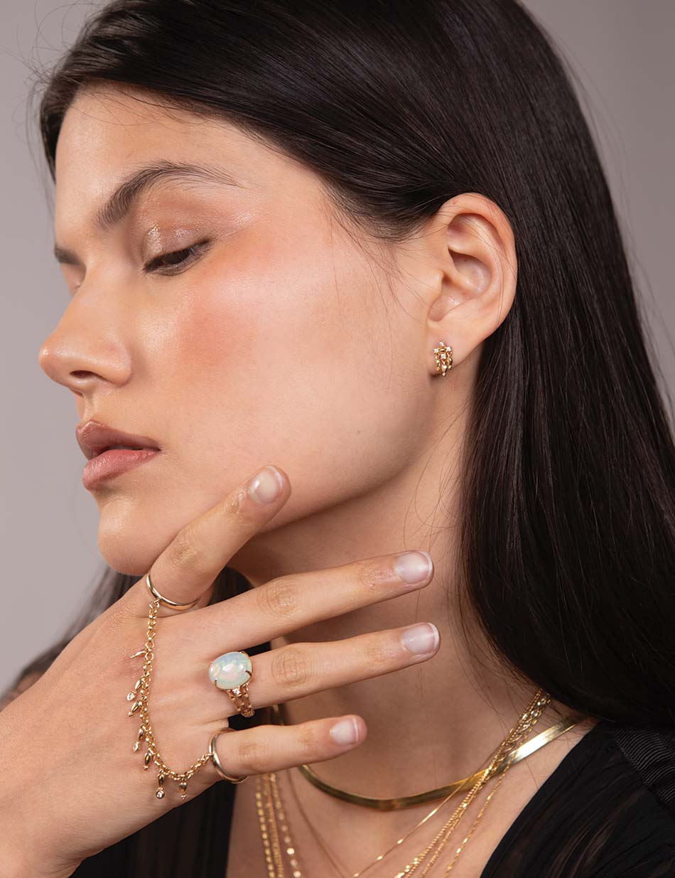 The gold and diamond fringe collection featuring the fringe stud earrings and hand piece by honey drip.