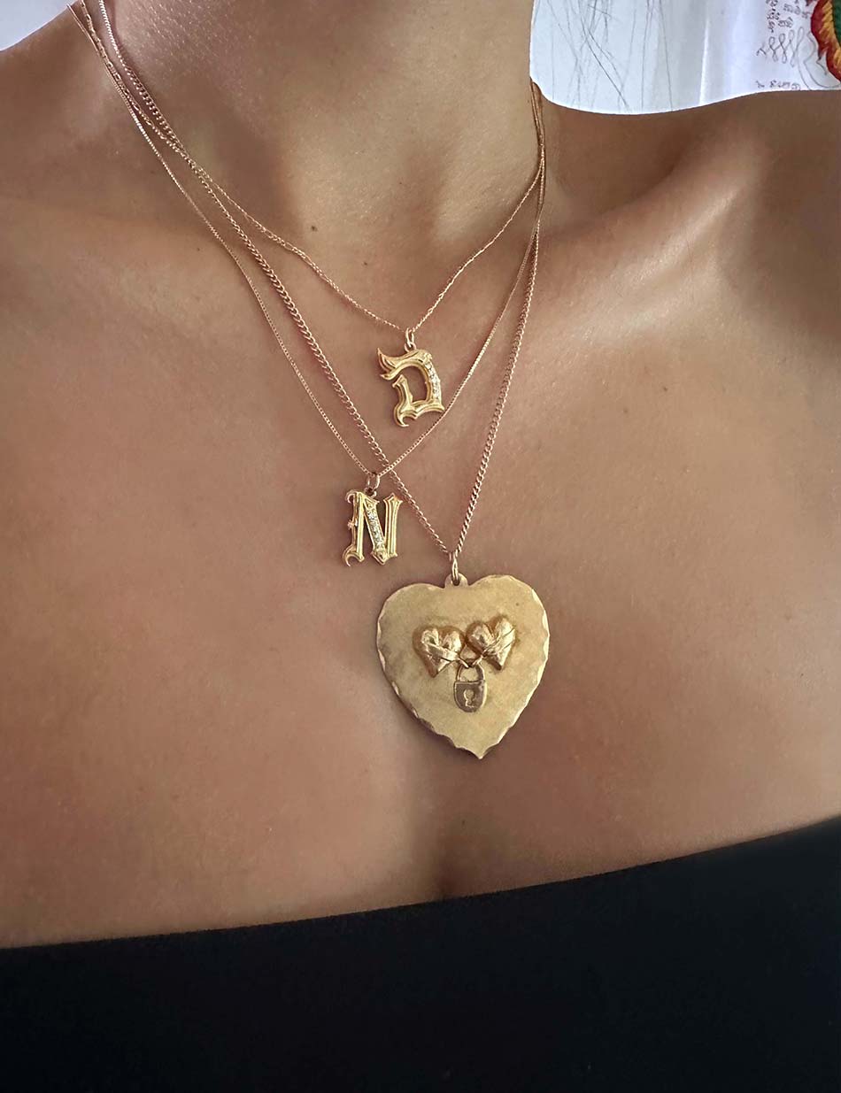 Gothic monogram charm pendants in 14k gold with white diamonds by Honey Drip Fine Jewelry paired with vintage heart pendant.