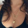 Person wearing a set of vintage 14k yellow gold charm necklaces that read "Spoil Me" and "Special" sourced by HONEY DRIP NYC