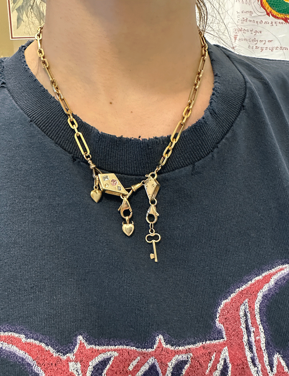 The crane blocks worn as chain extenders and charm holders